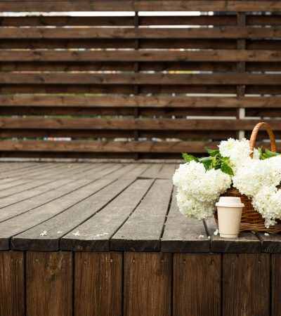 Coffee with flowers on the street, on a wooden background.