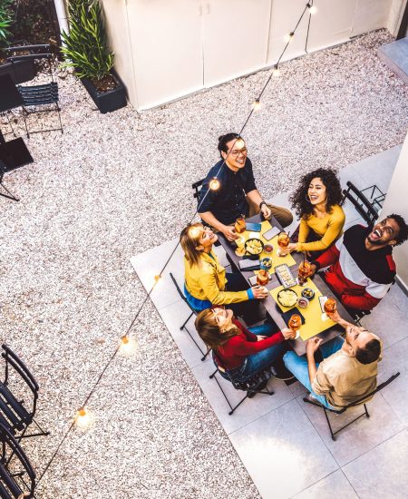 High angle top view of happy friends drinking cocktails and having fun at restaurant garden party - Food and beverage  concept with young people together at home patio - Dark warm filter