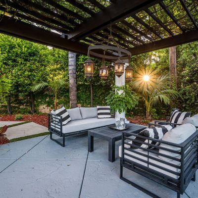 A patio with white couches and chairs in a modern new construction home in Los Angeles