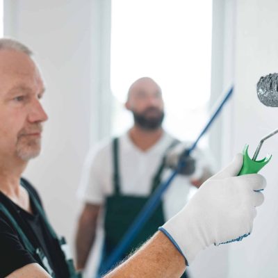 Renovation crew of three professional builders remodeling bright apartment