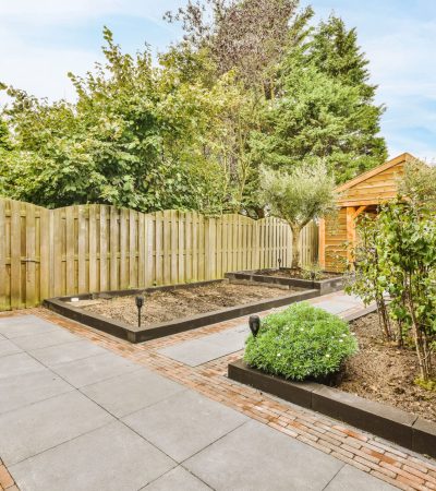 The backyard of the house with a garden and trees
